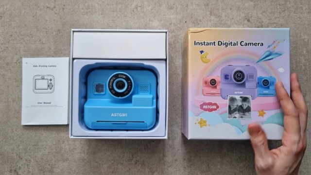 ASTGMI Kinderkamera in Blau beim Auspacken mit Geschenkverpackung und Anleitung